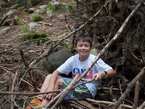 a boy sitting in a tree