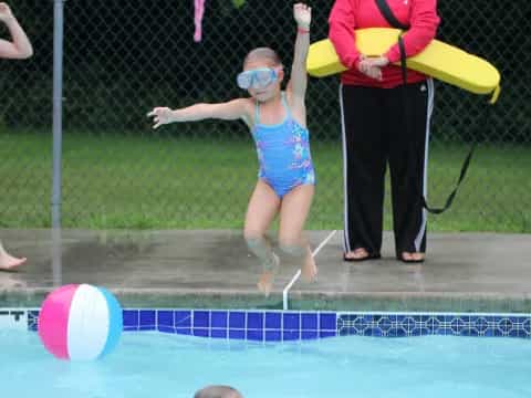 a girl jumping into a pool