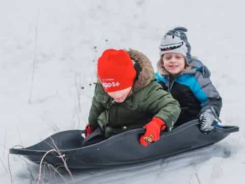 two kids on a sled