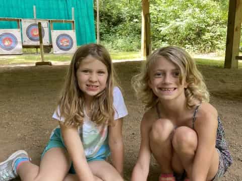 two girls sitting on the ground