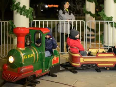 a kid riding a small train