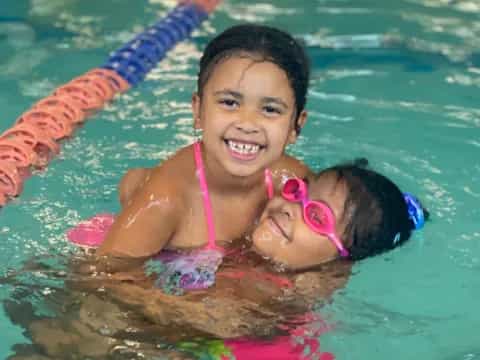 a girl and a baby in a pool