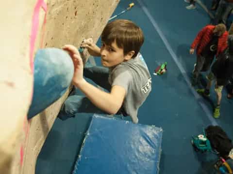 a boy climbing a rock wall