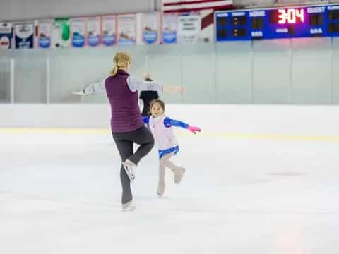 a woman and a girl ice skating