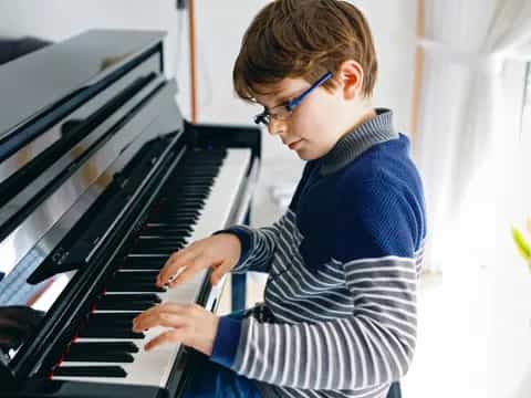 a boy playing a piano