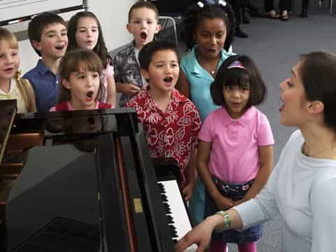 a group of children playing piano