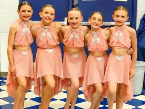 a group of girls in pink dresses