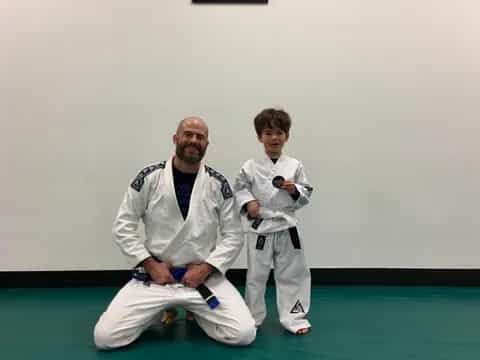 a man kneeling next to a boy