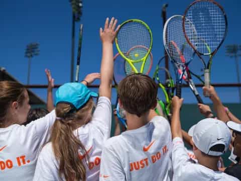 a group of kids playing tennis