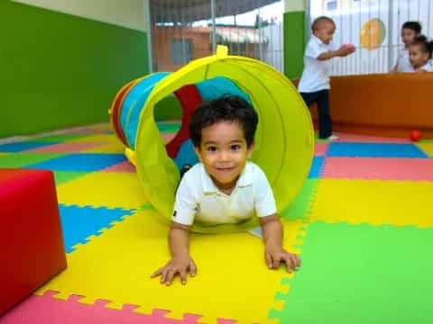 a child sitting on a colorful mat