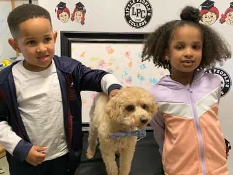 a boy and girl posing with a dog