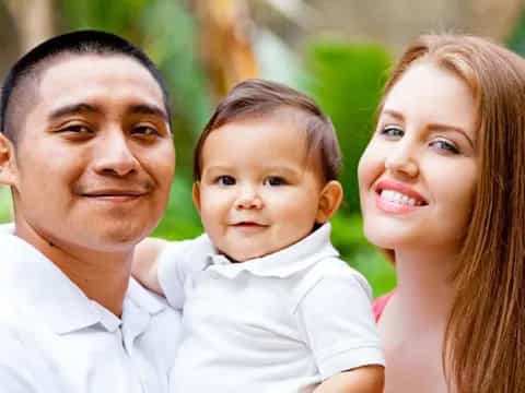 a man and woman holding a baby