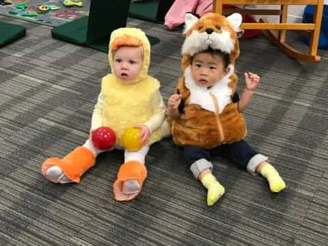 a couple of dolls sitting on a rug