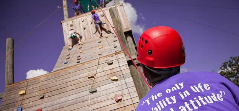 a group of people climbing a wooden structure
