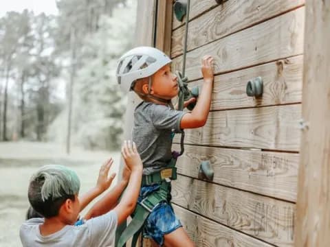 a boy climbing a fence