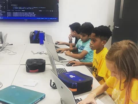 a group of kids using laptops