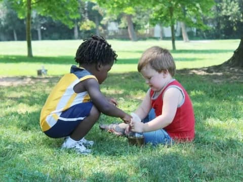two boys playing in the grass