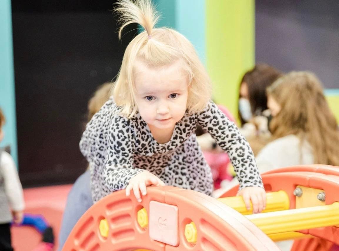 a little girl riding a toy train