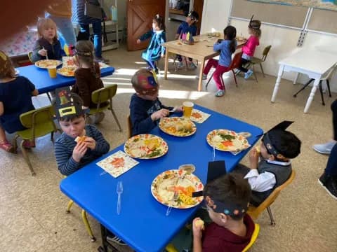 children eating pizza at a table