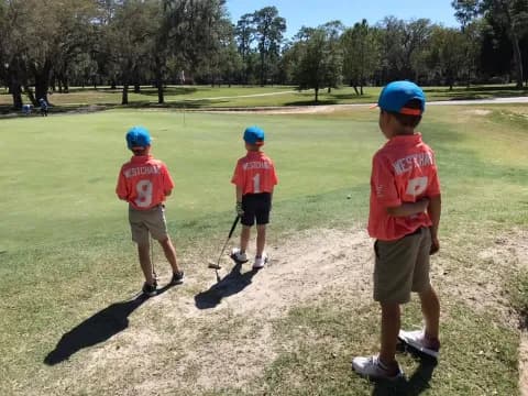 a group of kids playing golf