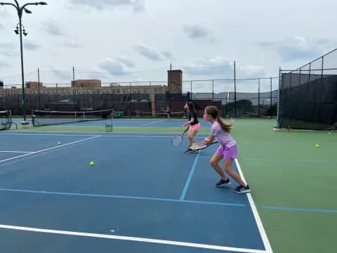 a couple of girls playing tennis