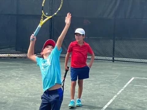 a couple of boys playing tennis
