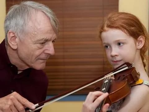 a man and a girl playing a violin
