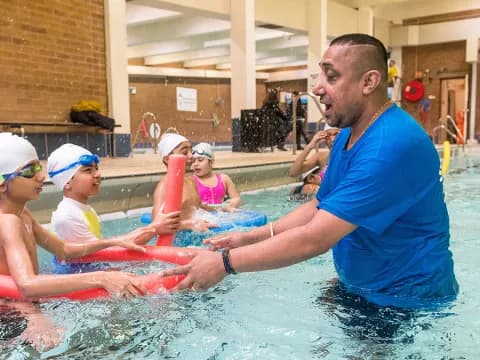 a person in a pool with kids