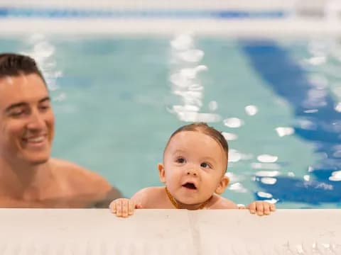 a person and a baby in a pool