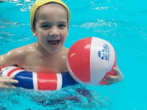 a boy in a pool with a ball