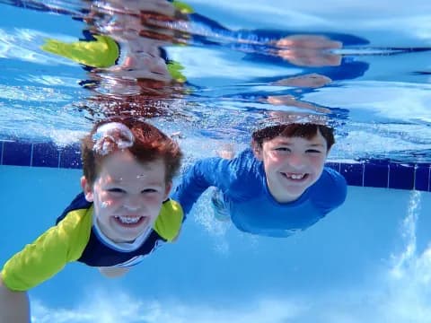 a couple of kids in a pool