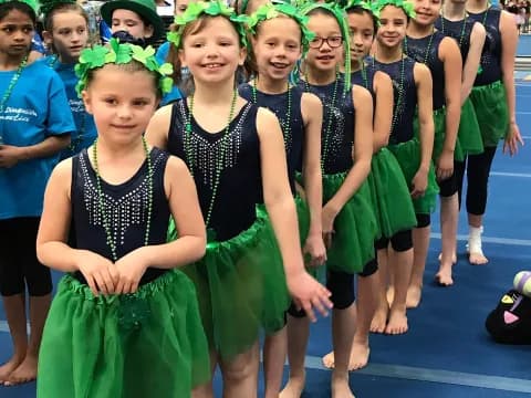 a group of girls in green dresses
