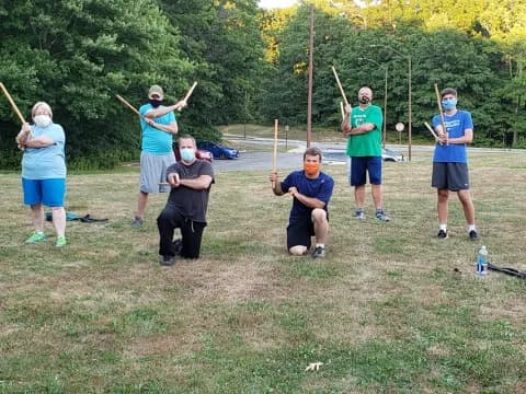 a group of people holding sticks