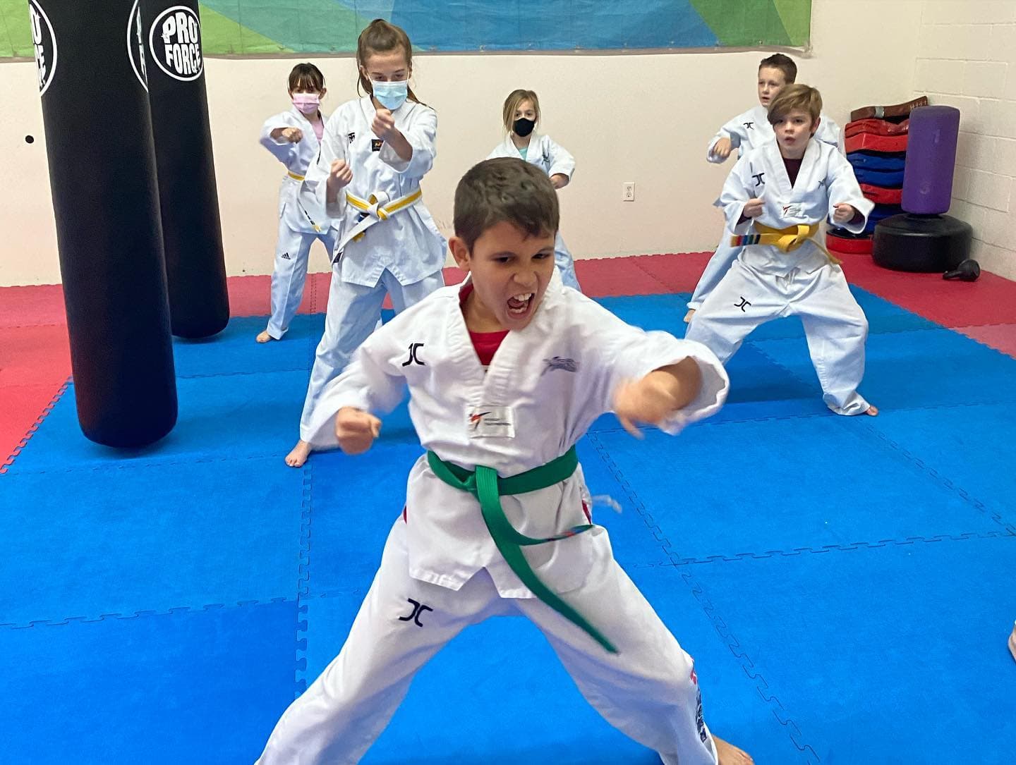 a group of kids in karate uniforms