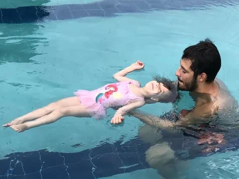 a person and a baby in a pool