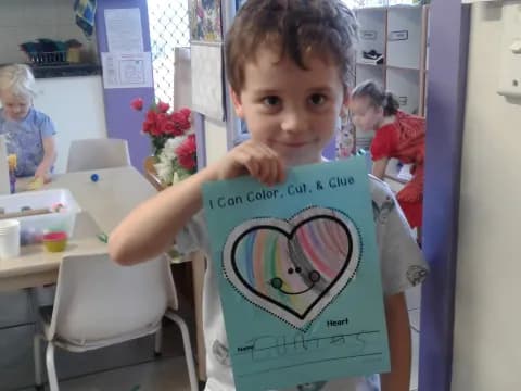 a boy holding a drawing