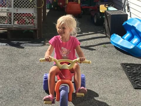 a girl riding a toy bike