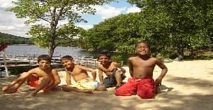 a group of boys sitting on a beach