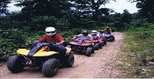 a group of people riding atvs
