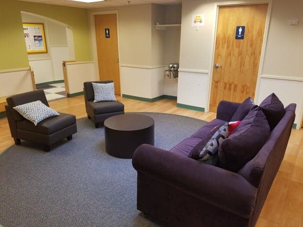 a room with purple couches and a wood floor