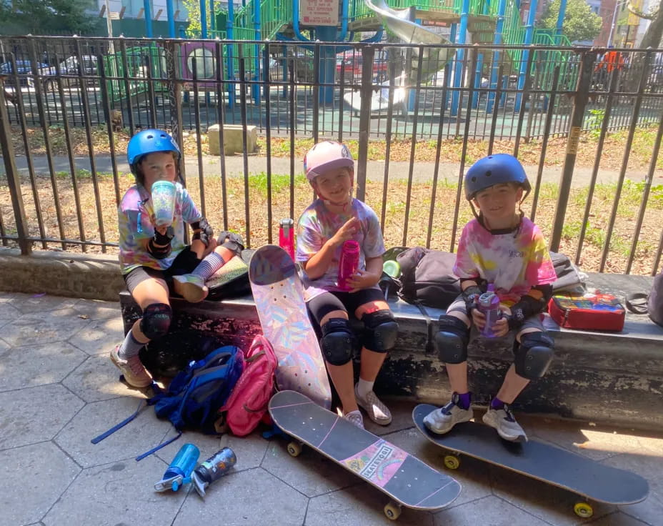 kids with skateboards on a sidewalk