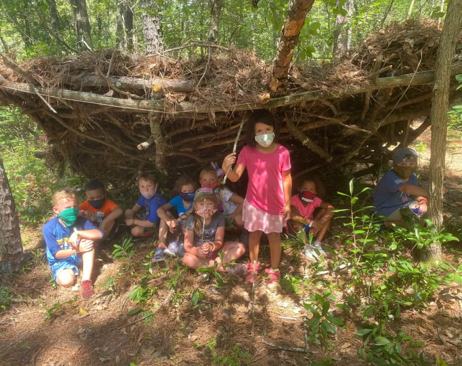 a group of kids in a wooded area