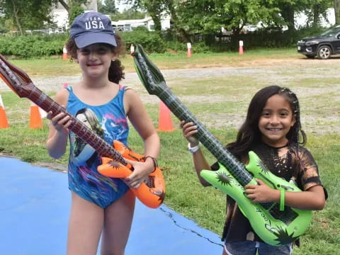 a couple of girls holding guitars