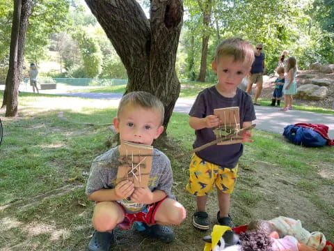 two boys sitting on the grass