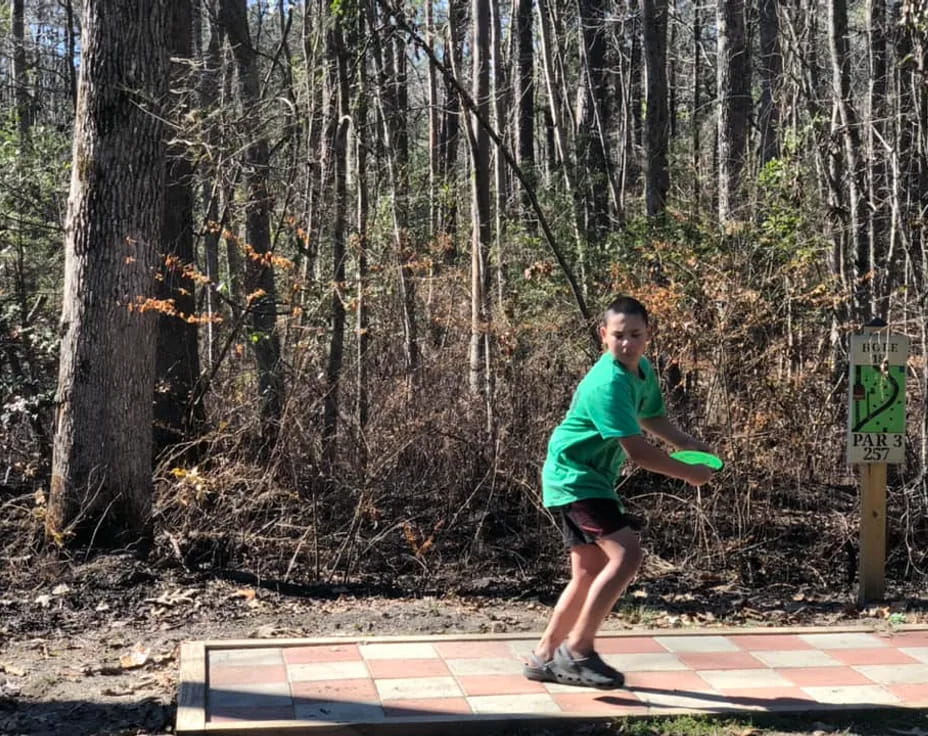 a boy throwing a frisbee