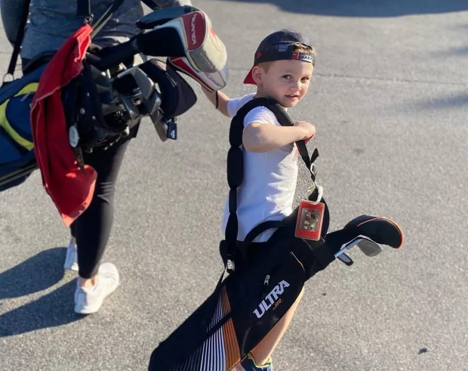 a boy holding a backpack