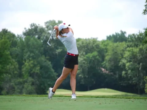 a woman swinging a golf club