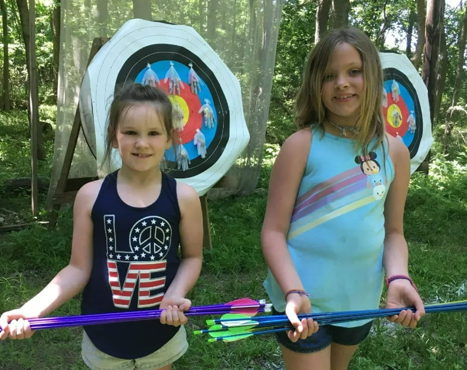 two girls holding bows and arrows