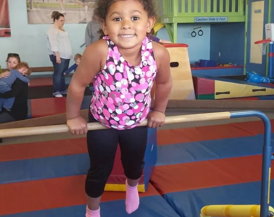 a girl standing on a blue mat