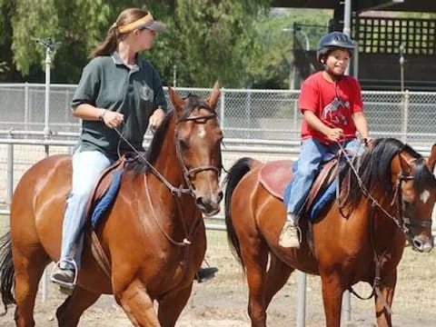 a couple of women riding horses